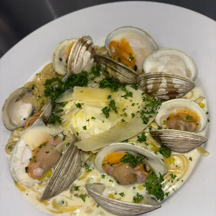 Clam Linguine al Limone — fresh clams over linguine in a creamy lemon sauce, finished with shaved parmesan and parsley